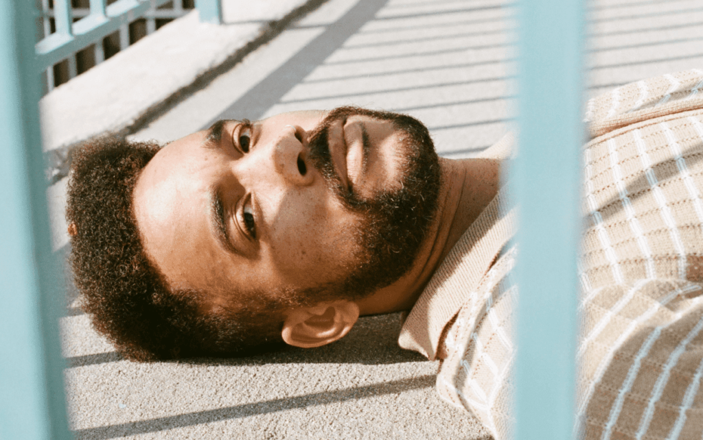 Title image: Man on the floor having negative thoughts